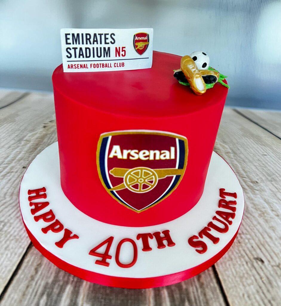Red Arsenal birthday cake, with Arsenal logo and football boots.