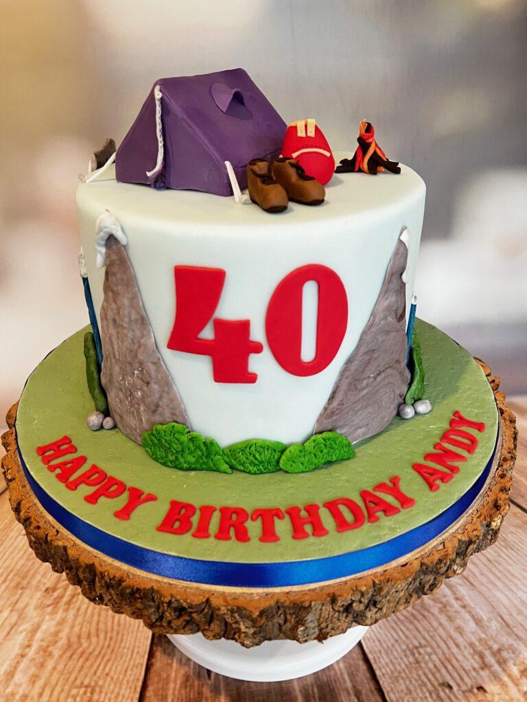 Hiking and outdoor cake. Decorated with mountains, hiking boots and a rucksack.