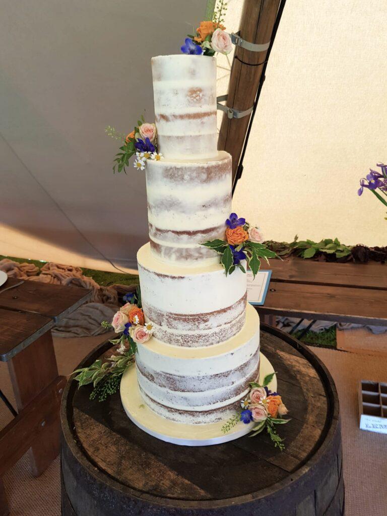 4 tier semi naked wedding cake with fresh flowers